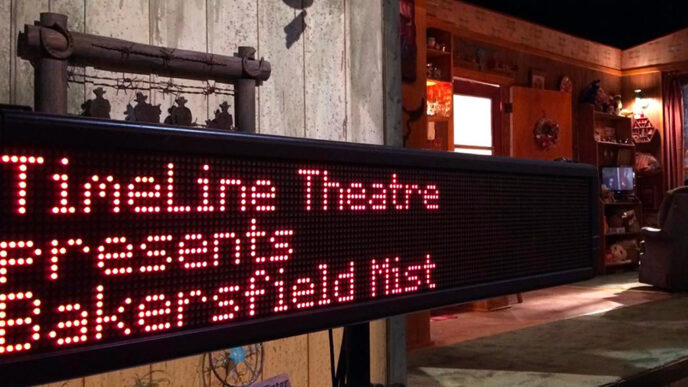 A captioning screen beside a theater stagereads TimeLine Theatre presents Bakersfield Mist
