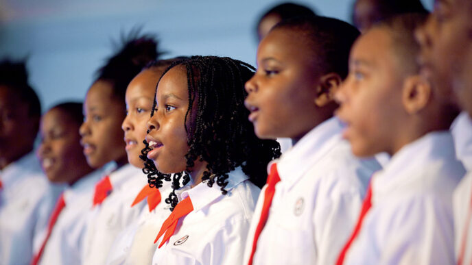A row of young singers in white shirts and red ties