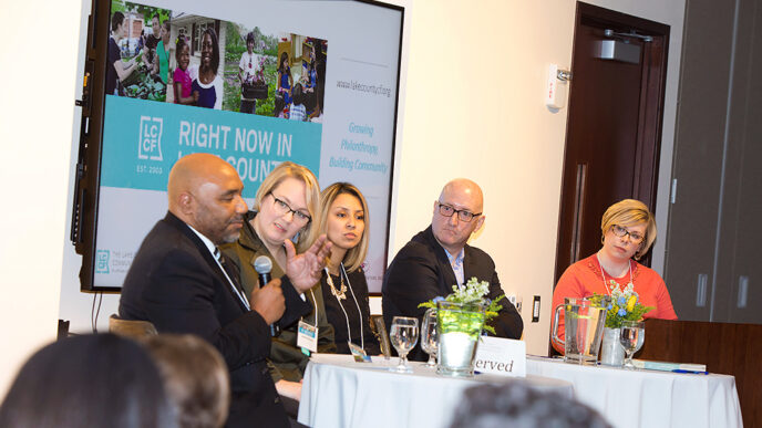 Five people seated in a row for a panel discussion
