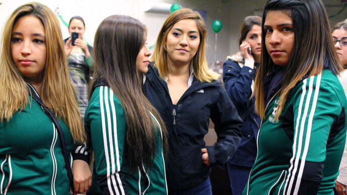 Girls from the Kelly High School soccer team discuss the film after a screening in the school auditorium||In a hallway at Kelly High School