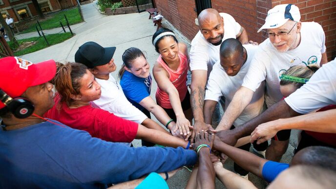 Volunteers and participants in the Back on my Feet program prepare for a run||Kathy Higa gives a high-five to a runner|Sherita Mallit shares advice with a fellow runner during warmup