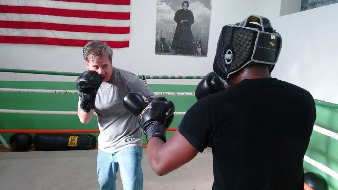 Celtic Boxing Club founder Mike Joyce and trainee Gregory George in the ring|A local fighter trains in the gym at Celtic Boxing Club