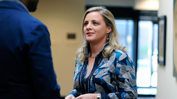 Randi Belisomo listens during a conversation in a hallway||