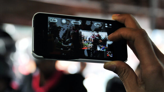 Close-up of a phone taking photos of a group of people
