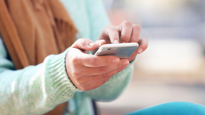 Hands holding a phone and texting|Nancy Lublin riding a bicycle