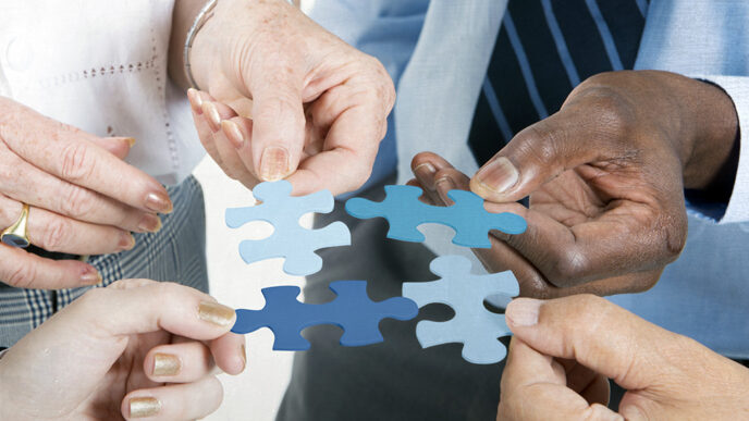 Hands holding puzzle pieces and fitting them together