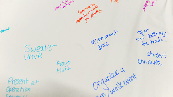 Notes written in marker from a brainstorming session capture ideas for raising awareness about mental health|Elizabeth Einig during a meeting in her school library|Elizabeth Einig with two classmates amid tribal artworks at the Trickster Gallery