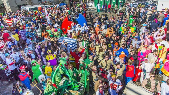 A large crowd in colorful costumes gathers at the starting line of the Chiditarod charity race|