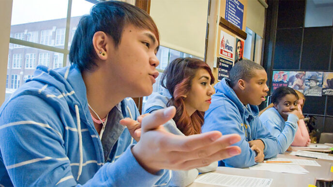 Four high school students in conversation during class|Pie chart representing Chicago high school students served by categories of school. Neighborhood Public High Schools: 42.5%