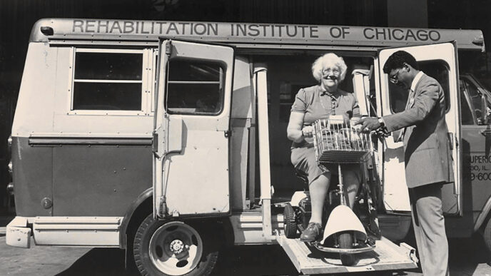 Archival photo shows women using mobility scooter entering a Rehabilitation Institute of Chicago van|