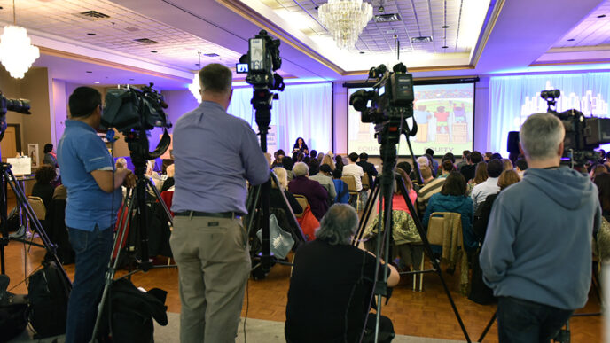 News cameras record the launch event for the Generation All Action Plan|Students from the Kelly High School mentoring program in conversation with event guests|||