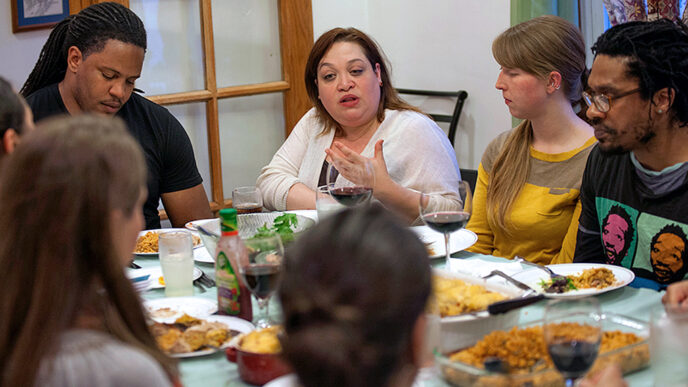 An intergenerational group in conversation around a dinner table