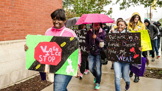 Marchers carry signs in a walk to protest violence against women