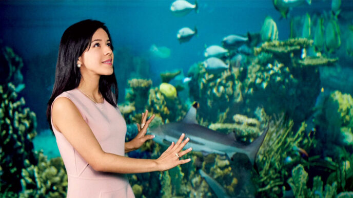 Daniela Fernandez stands in front of an aquarium tank|Daniela Fernandez backstage at WE Day Illinois