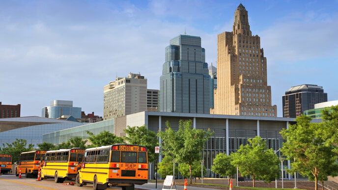 Buses outside a school in Kansas City with the skyline in the background|Kansas City Mayor James with two staff members from Communities Creating Opportunity