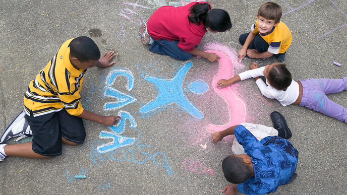 Children coloring and drawing the CASA logo with sidewalk chalk