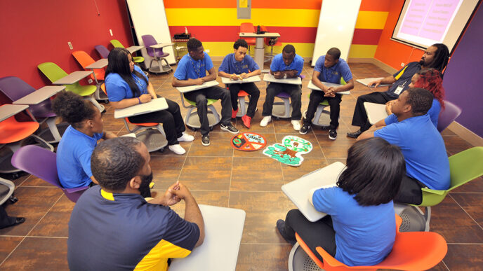 Students sit in a circle in a brightly painted