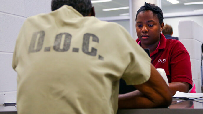 A staff member from TASC visits with an inmate
