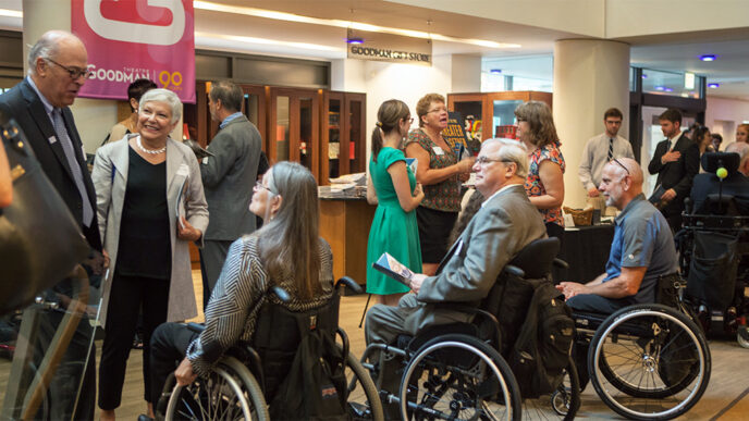 A group of people talking in the lobby of the Goodman Theatre|A group of people talking in the lobby of the Goodman Theatre