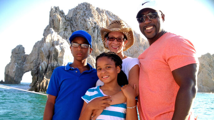 Erika Lyn Huie Downs and family smiling in front of a seaside view