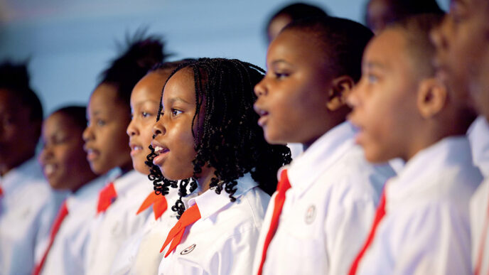 A row of young singers in white shirts and red ties