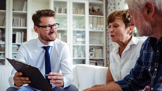 A financial advisor sits beside an older couple