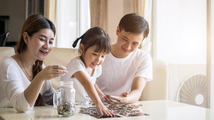 A little girl site with her parents in a living room