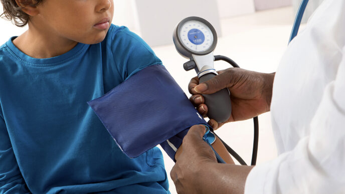 Close-up view of a young child's arm wrapped in a blood pressure cuff