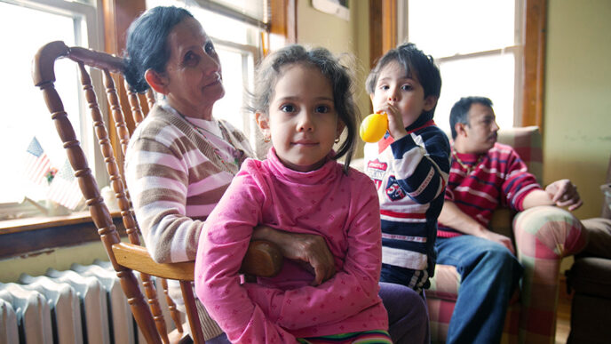 A family of four sit in a living room