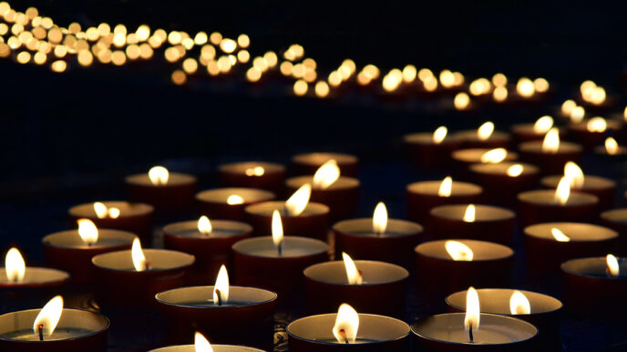 A path of lit candles against a dark background